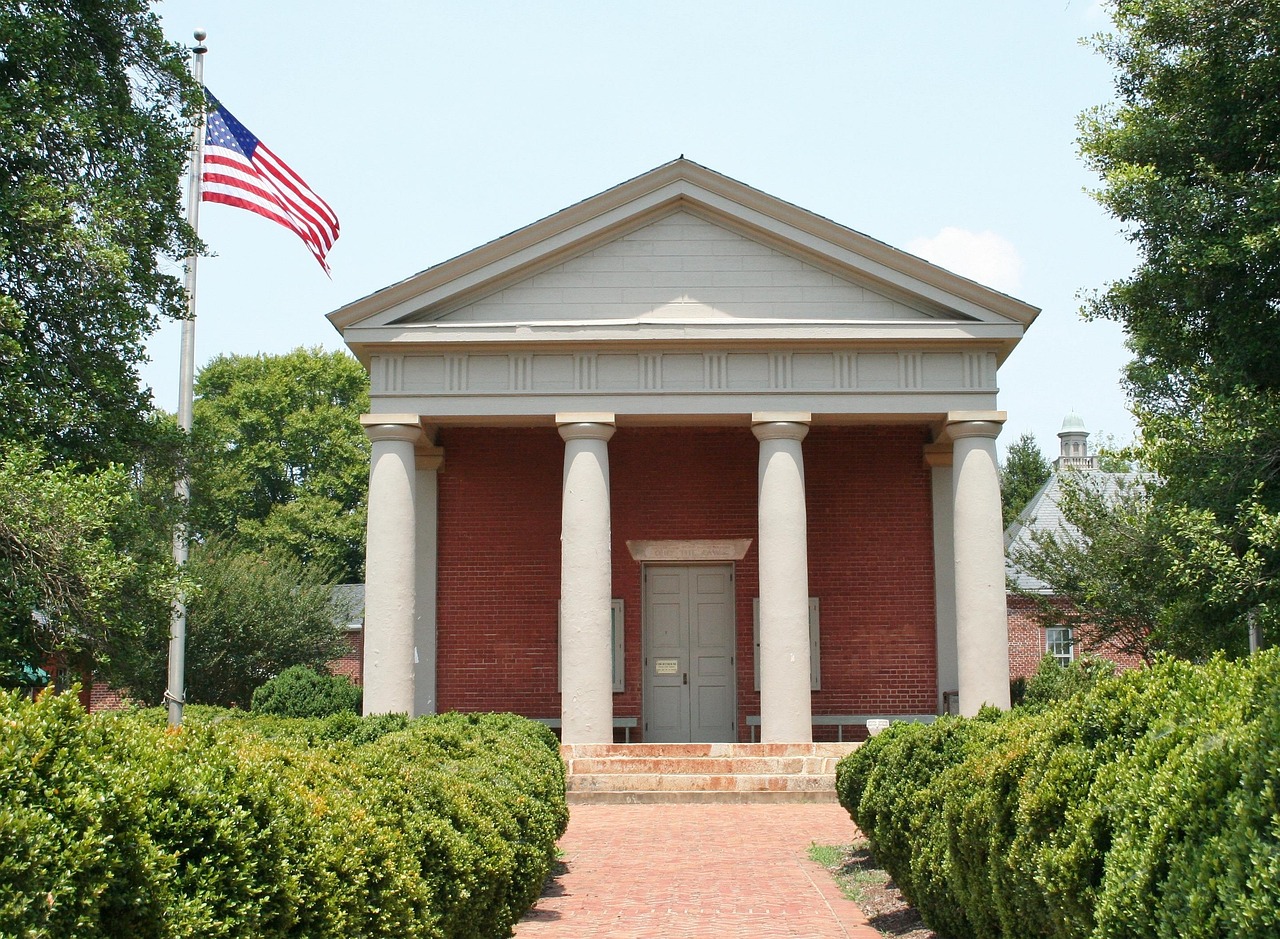 A courthouse with a colonnade, seen from the footpath
